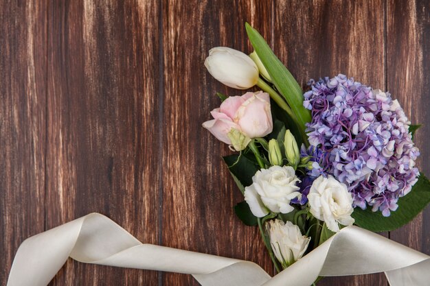 Vista superior de hermosas flores como tulipán gardenzia y rosas aisladas sobre un fondo de madera con espacio de copia