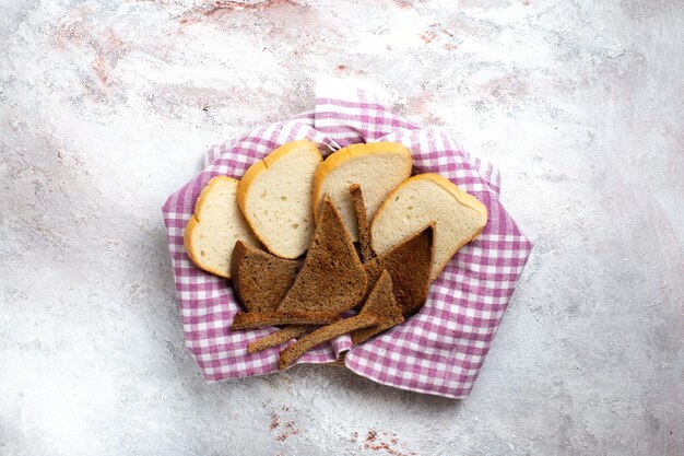 Vista superior de las hogazas de pan en rodajas de pan en el escritorio blanco pan bollo comida comida