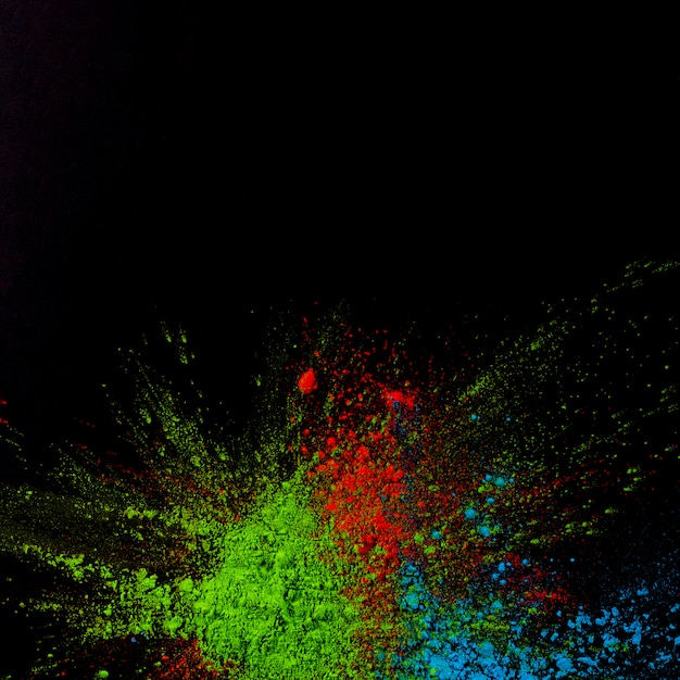 Foto gratuita la vista superior del holi verde, azul y rojo coloreó el polvo sobre fondo negro