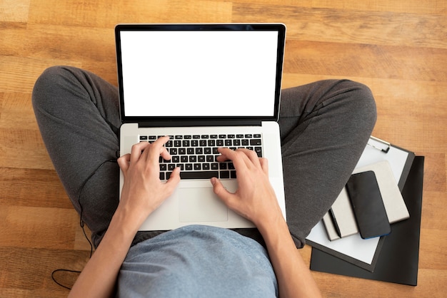 Vista superior del hombre cómodo en cuarentena en casa usando la computadora portátil para el trabajo