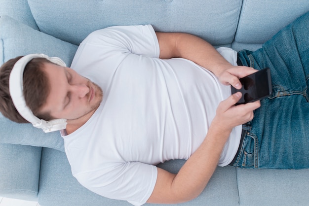 Foto gratuita vista superior hombre escuchando música en auriculares