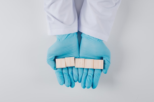 Foto gratuita vista superior del hombre en guantes con bloques de madera en ambas manos en blanco