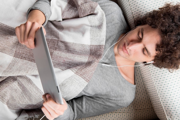 Foto gratuita vista superior hombre con tableta y auriculares