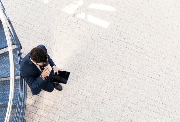 Foto gratuita vista superior hombre con tableta tomando café