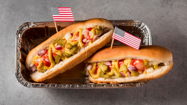 Vista superior de hot-dogs con bandera americana en bandeja