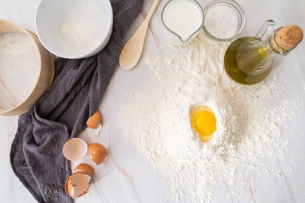 Vista superior de huevo en harina rodeado de ingredientes
