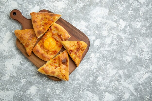 Vista superior de huevo en rodajas pastelería pan horneado sobre piso blanco pastelería horno masa comida comida pan bollo