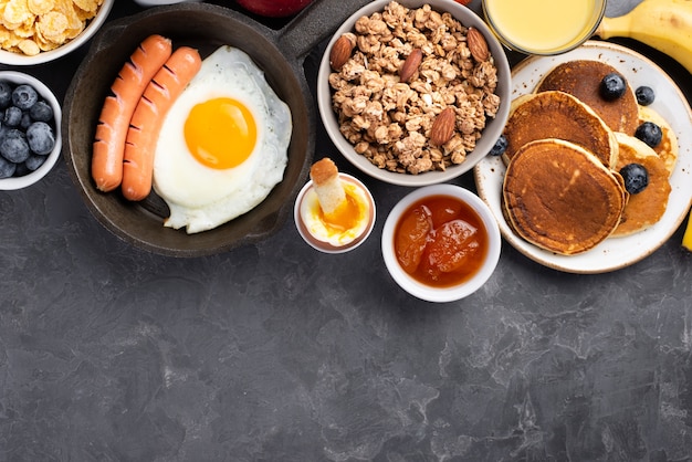 Vista superior de huevo con salchichas y cereales para el desayuno.