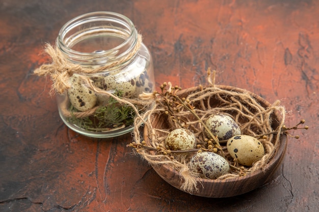 Vista superior de huevos frescos de granja en una olla de madera y en un vaso sobre un fondo marrón