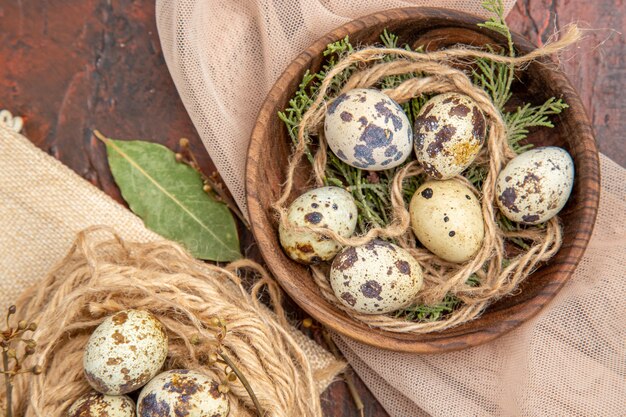 Vista superior de huevos frescos de granja en un rollo de cuerda en una bolsa y en una olla sobre una mesa marrón