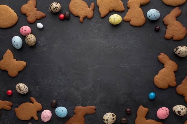 Vista superior de huevos y galletas en forma de conejito para el marco de pascua