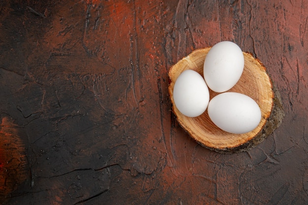 Vista superior de los huevos de gallina blanca en la mesa oscura comida animal comida en color foto cruda granja espacio libre