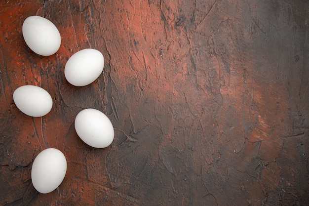 Vista superior de huevos de gallina blanca en mesa oscura comida de animales granja de alimentos