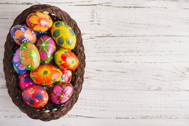 Vista superior de huevos de pascua en una cesta de mimbre