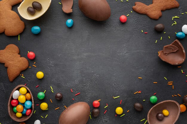 Vista superior de huevos de pascua de chocolate con bastidor de dulces y galletas