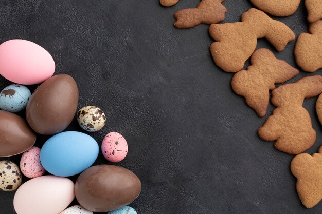 Vista superior de huevos de pascua de chocolate con galletas en forma de conejito