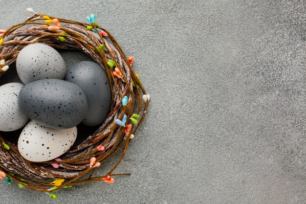 Vista superior de huevos de pascua de colores en la canasta con espacio de copia