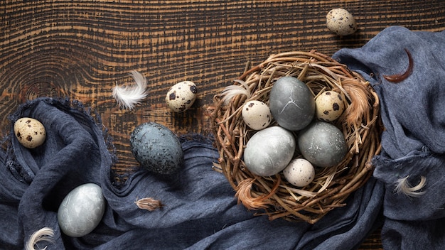 Vista superior de huevos de pascua con plumas en nido de pájaro