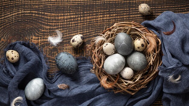 Vista superior de huevos de pascua con plumas en nido de pájaro