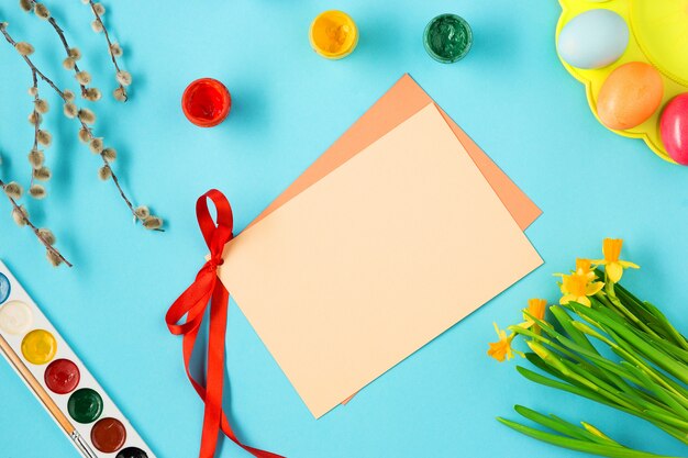 Vista superior de huevos de Pascua y tarjeta de felicitación en blanco