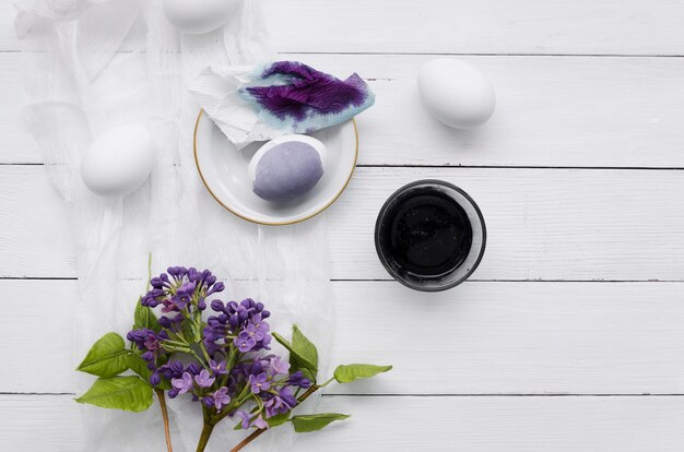 Vista superior de huevos teñidos para pascua con flores lilas