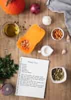 Foto gratuita vista superior de ingredientes alimentarios con calabaza y cuaderno