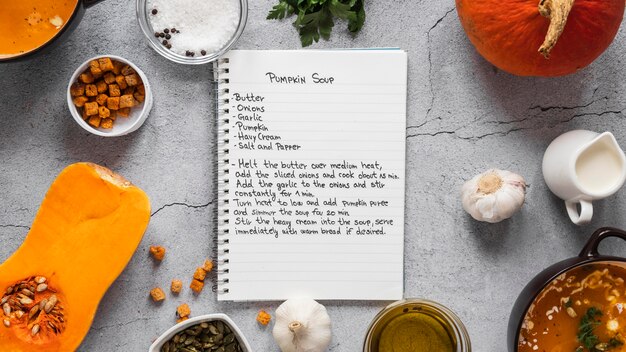 Vista superior de ingredientes alimentarios con verduras y cuaderno