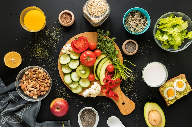 Vista superior de los ingredientes; frutos secos y verduras sobre fondo negro