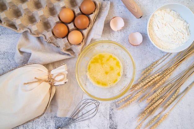 Vista superior de ingredientes de pasta con utensilios de cocina.