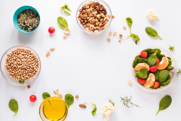 Vista superior de ingredientes saludables en tazones sobre fondo blanco con espacio en blanco para texto