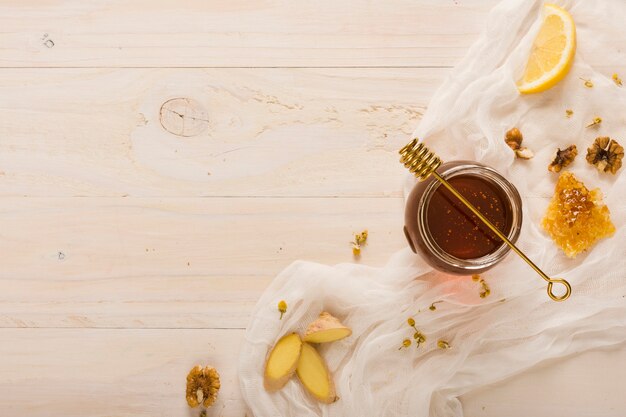 Vista superior jarra de miel con comida y cuchara de miel