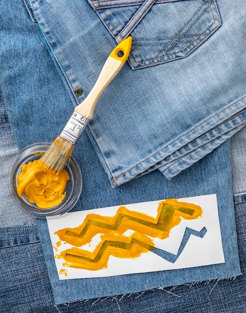 Vista superior de jeans y pintura amarilla.