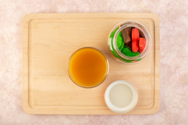 Una vista superior de jugo de durazno fresco dulce y delicioso con galletas de colores dentro de lata