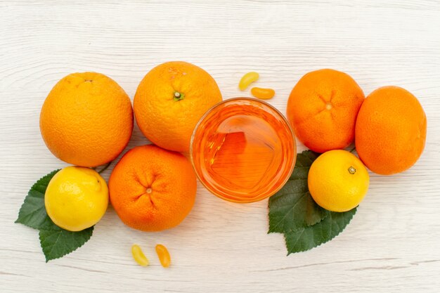 Vista superior de jugo de naranja con naranjas y cítricos en superficie blanca jugo de frutas tropicales exóticas cítricas