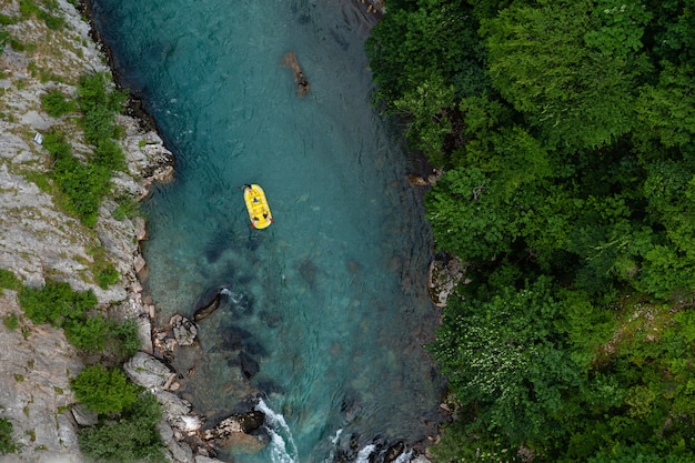 Vista superior de un kayak en un río capturado durante el día en el bosque