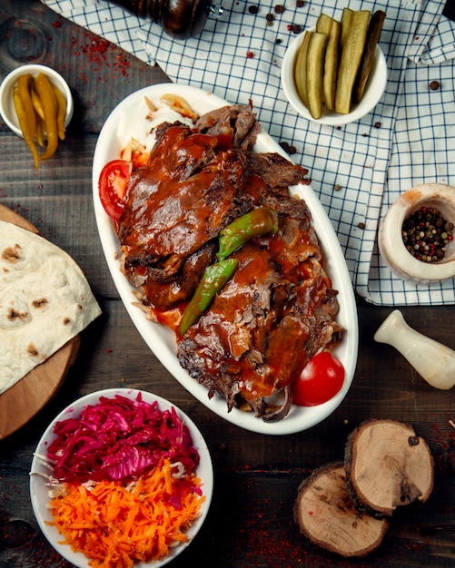 Vista superior del kebab iskender adornado con salsa de tomate