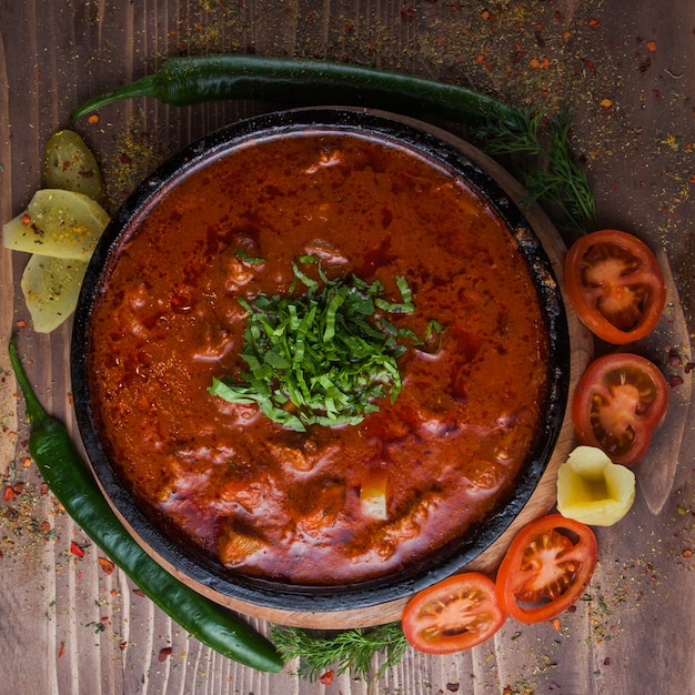 Foto gratuita vista superior kharcho con pimiento verde y tomate y verduras en plato oscuro