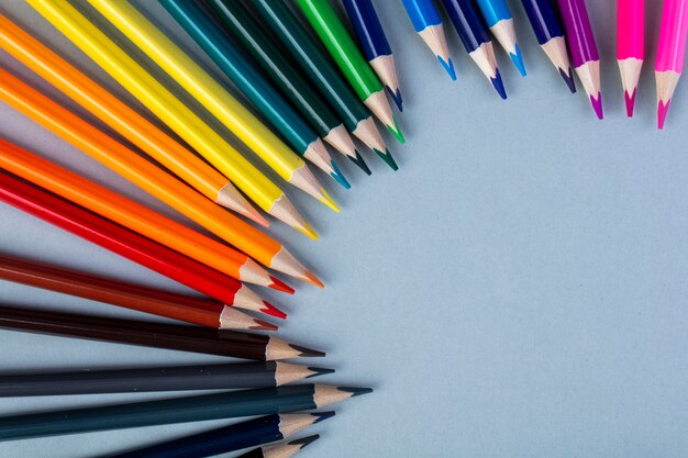 Vista superior de lápices de colores dispuestos en blanco con espacio de copia