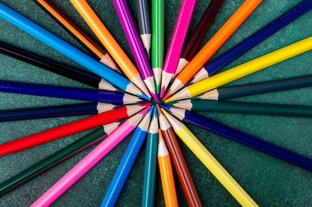 Vista superior de lápices de colores en la oscuridad