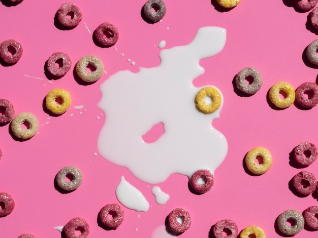 Vista superior de leche y cereales sobre fondo rosa