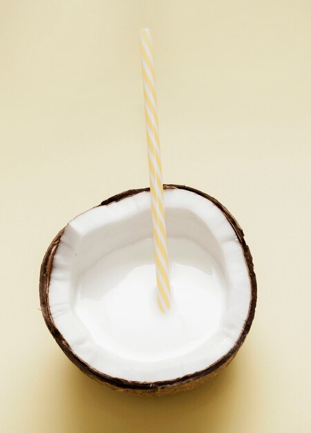 Vista superior de leche de coco con pajita de plástico