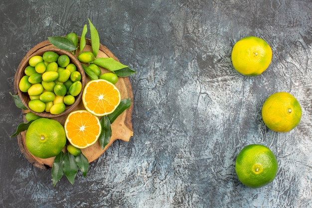 Vista superior desde lejos cítricos naranjas mandarinas en la tabla de cortar