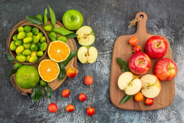 Vista superior desde lejos frutas cítricos cerezas manzanas rojas en el tablero