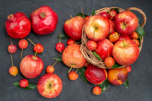 Vista superior desde lejos frutas manzanas cerezas en la canasta granadas nectarina