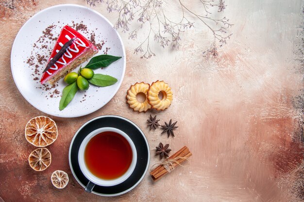 Vista superior desde lejos un pastel galletas canela en rama una taza de té plato de pastel