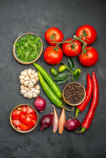 Vista superior desde lejos verduras tomates con pedicelos pimientos picantes ajo hierbas especias cítricos