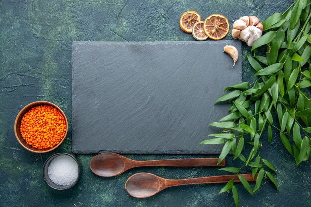 Vista superior de lentejas naranjas con ajo y sal sobre fondo azul oscuro foto comida picante pimiento picante color sopa de semillas afiladas