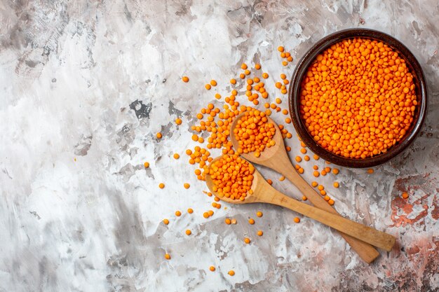 Vista superior de lentejas naranjas crudas sobre fondo claro sopa de plantas foto en color semilla de alimentos