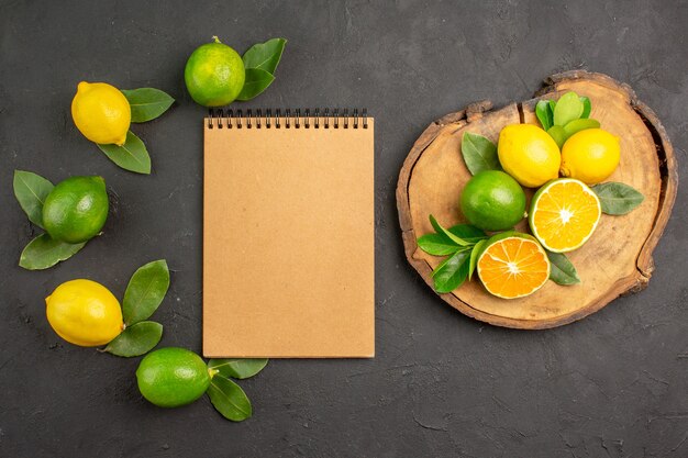 Vista superior de limones agrios frescos en la mesa de color gris oscuro fruta cítricos lima