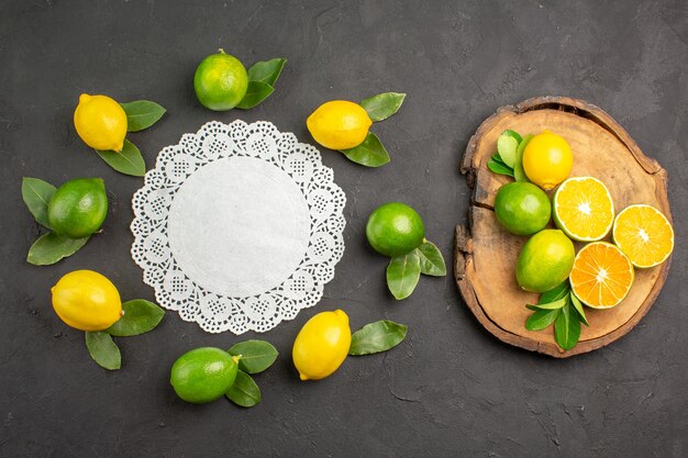 Vista superior de limones agrios frescos en la mesa de color gris oscuro, fruta de lima, cítricos